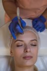 Kosmetikerin behandelt Kundin mit Maschine im Salon — Stockfoto