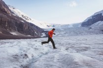 Mann läuft im Winter durch eine Schneelandschaft — Stockfoto