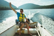 Homme voyageant en bateau à moteur sur un lac — Photo de stock
