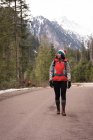 Продумана жінка ходить з рюкзаком на дорозі взимку — стокове фото