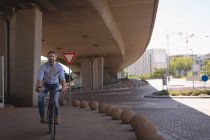 Чоловік їде на велосипеді на вулиці в сонячний день — стокове фото