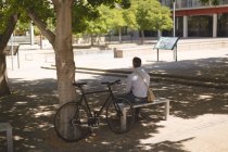 Vista posteriore dell'uomo seduto sulla panchina nel parco — Foto stock