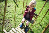 Хлопчик розслабляється в гойдалках на сонячний день в саду — стокове фото