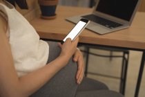 Schwangere Geschäftsfrau nutzt Handy am Schreibtisch im Büro — Stockfoto