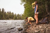 Couple drinking water near river on a sunny day — Stock Photo