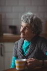 Nachdenkliche Seniorin beim Kaffee zu Hause — Stockfoto
