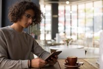 Junger Mann benutzt digitales Tablet in Cafeteria — Stockfoto