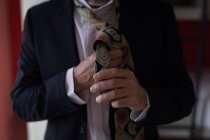 Close-up de homem de negócios amarrando sua gravata no quarto de hotel — Fotografia de Stock