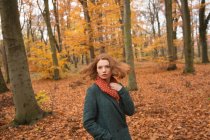 Frau steht im Herbst mit der Hand in der Tasche im Park — Stockfoto