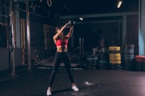 Fit woman exercising with quettlebell in the gym — стоковое фото