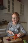 Fille coupe des légumes dans la cuisine à la maison — Photo de stock