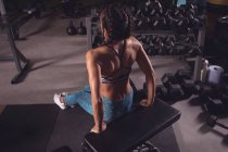 Fit mujer haciendo ejercicio en el banco de gimnasio en el gimnasio - foto de stock