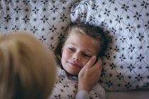 Madre si sveglia sua figlia sul letto a casa — Foto stock