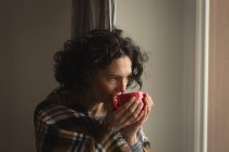 Удумлива жінка має каву вдома — стокове фото