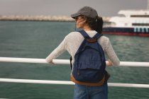 Вид сзади женщины с рюкзаком, стоящей на круизном лайнере — стоковое фото