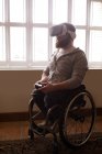 Homem com deficiência usando fone de ouvido de realidade virtual em casa — Fotografia de Stock