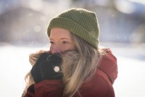 Nahaufnahme einer Frau in Winterkleidung, die auf einer verschneiten Landschaft steht — Stockfoto