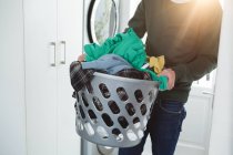 Homem segurando cesta de roupas de lavanderia em casa — Fotografia de Stock