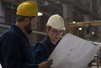 Технік обговорює план зі своїм колегою по металургії — стокове фото