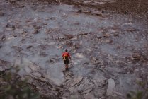 Visão traseira do homem em pé no riacho — Fotografia de Stock