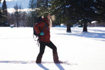 Mulher andando na neve paisagem coberta em um dia ensolarado — Fotografia de Stock