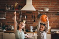 Girls in costume dancing playing in kitchen at home — Stock Photo