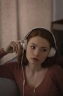 Frau hört zu Hause Musik über Kopfhörer — Stockfoto