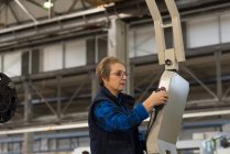 Técnico feminino operando máquina na indústria de metal — Fotografia de Stock