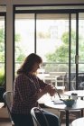 Femme d'affaires utilisant smartwatch à la cafétéria au bureau — Photo de stock