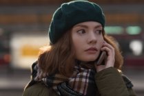 Nahaufnahme einer Frau in Winterkleidung, die mit dem Handy telefoniert — Stockfoto