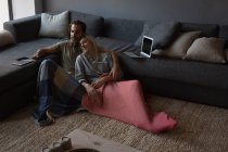 Casal assistindo televisão na sala de estar em casa — Fotografia de Stock