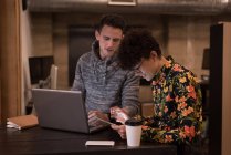 Чоловік і жінка-виконавця обговорюють цифровий планшет в офісі — стокове фото