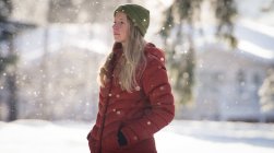 Продуманий жінку, що стоїть на засніжених краєвид протягом зими — стокове фото
