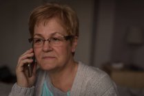 Старші жінки говорити на мобільний телефон у вітальні на дому — стокове фото