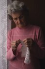 Aktive Seniorin strickt zu Hause Wolle — Stockfoto