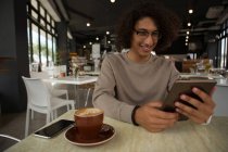 Щасливий чоловік використовує цифровий планшет у ресторані — стокове фото