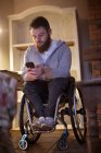 Uomo disabile che utilizza il telefono cellulare a casa — Foto stock