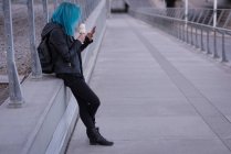 Стильна жінка має морозиво під час використання мобільного телефону — стокове фото