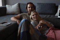 Couple regardant la télévision dans le salon à la maison — Photo de stock