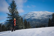 Жінка ходить на сніжному схилі в сонячний день — стокове фото