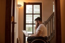 Behinderter junger Mann benutzt Laptop zu Hause — Stockfoto