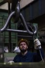 Attentive technician adjusting metal equipment in hook — Stock Photo