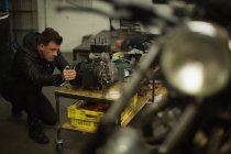 Mechaniker repariert Motorrad-Motor in Garage — Stockfoto