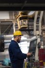 Técnico atencioso operando máquina na indústria de metal — Fotografia de Stock