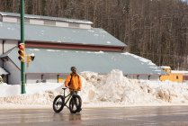 Mann läuft im Winter mit Fahrrad auf Straße — Stockfoto