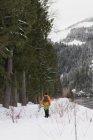 Mann geht im Winter mit Hund in verschneiter Landschaft spazieren — Stockfoto
