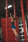 Visão traseira da mulher muscular praticando puxar para cima em uma barra de puxar para cima — Fotografia de Stock