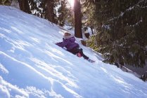 Unbekümmertes Mädchen spielt im Winter im Schnee — Stockfoto