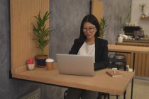 Grávida empresária trabalhando no laptop na mesa no escritório — Fotografia de Stock