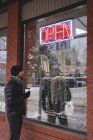 Молодой человек смотрит на витрину магазина — стоковое фото